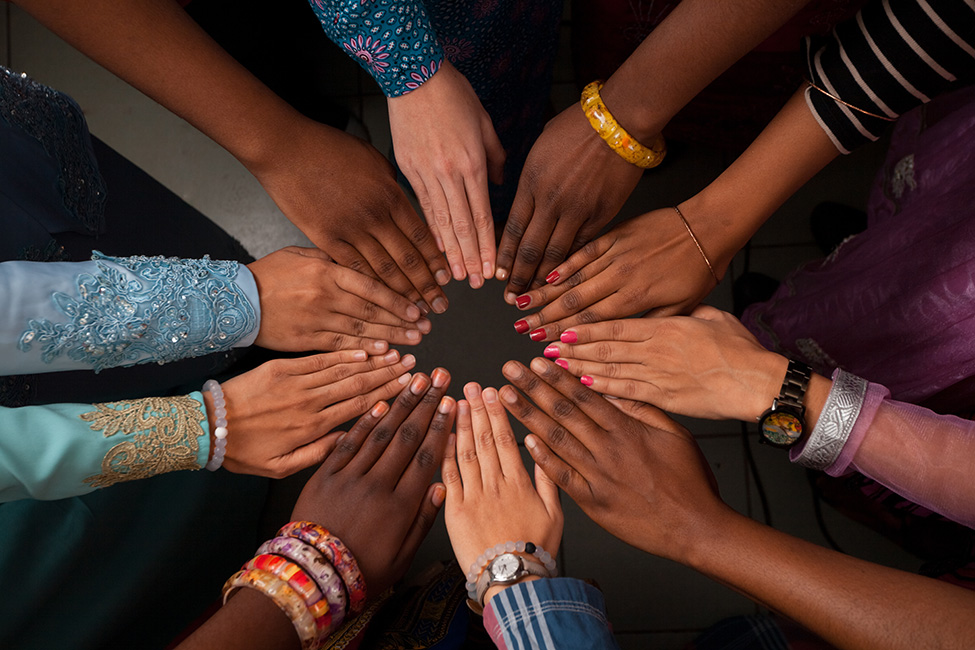 Youth workers with hands in a circle